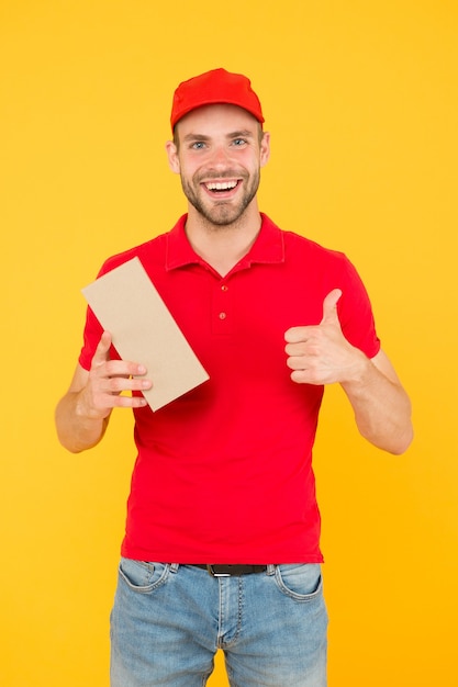 Super fast courier agent. Service delivery. Salesman career. Courier and delivery. Postman delivery worker. Man red cap yellow background. Delivering purchase. Delivering happiness and needs.