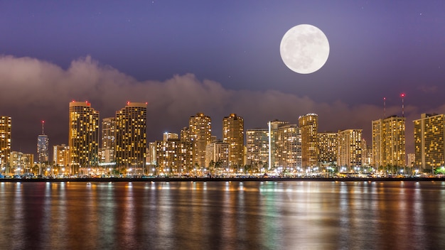 Super full moon over Honolulu downtown at night