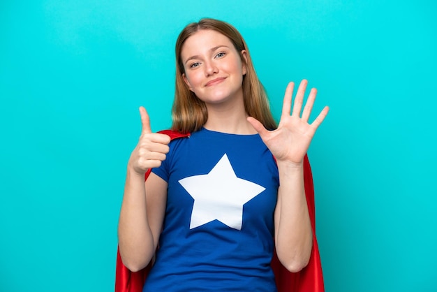 Super held blanke vrouw geïsoleerd op blauwe achtergrond zes tellen met vingers
