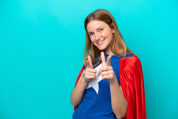 Foto super hero blanke vrouw geïsoleerd op blauwe achtergrond naar voren wijzend en glimlachend