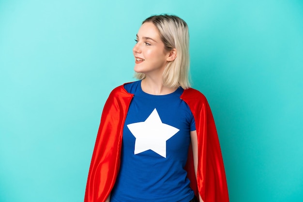 Super Hero blanke vrouw geïsoleerd op blauwe achtergrond op zoek naar kant