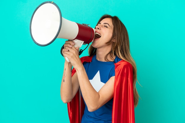 Super hero blanke vrouw geïsoleerd op blauwe achtergrond schreeuwen door een megafoon