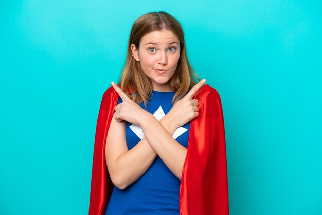 Super Hero blanke vrouw geïsoleerd op blauwe achtergrond wijzend naar de zijtakken die twijfels hebben
