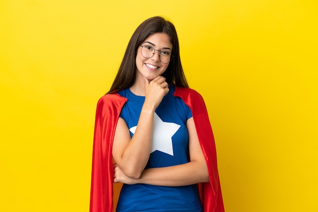 Super Hero Braziliaanse vrouw geïsoleerd op gele achtergrond met een bril en lachend