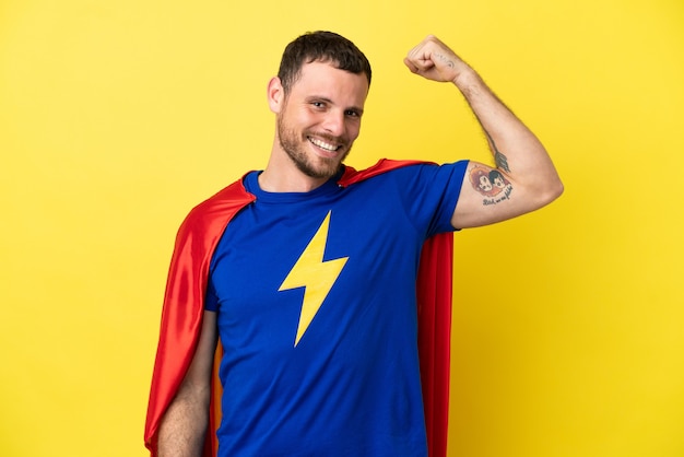 Photo super hero brazilian man isolated on yellow background doing strong gesture