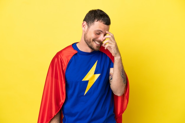 Foto super eroe brasiliano uomo isolato su sfondo giallo ridendo