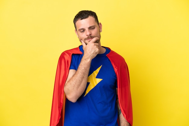 Super Hero Brazilian man isolated on yellow background looking to the side