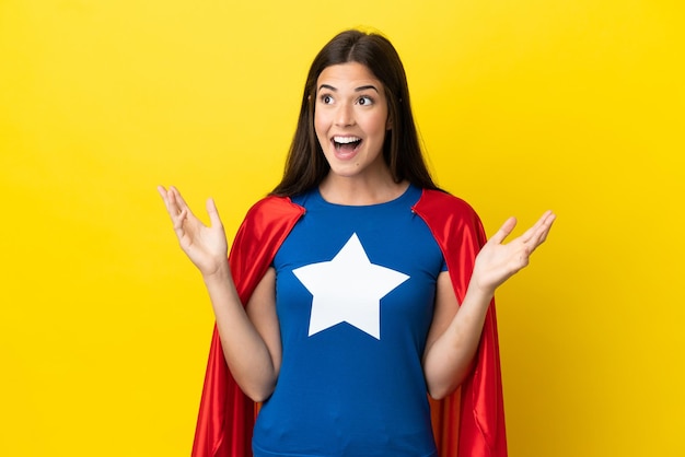 Super hero brazilian woman isolated on yellow background with surprise facial expression