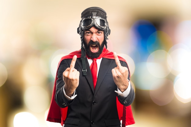 Super hero businessman making horn gesture on unfocused background