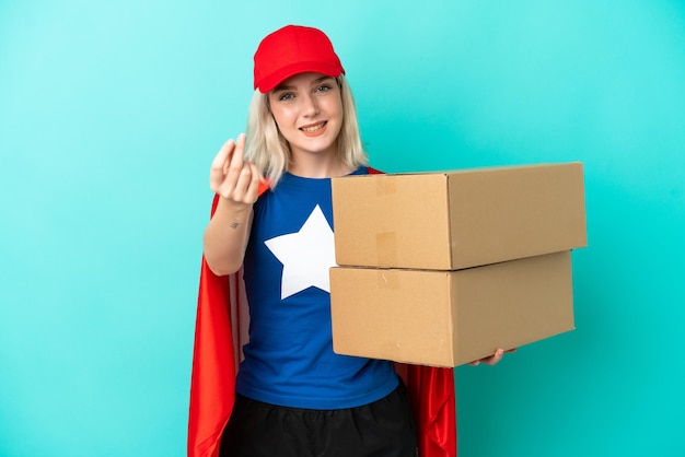 Super Hero caucasian delivery woman isolated on blue background making money gesture