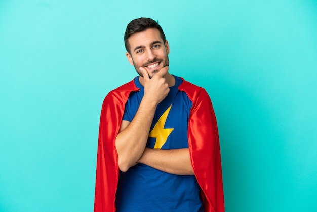 Кавказский человек супергероя изолирован на синем фоне улыбается