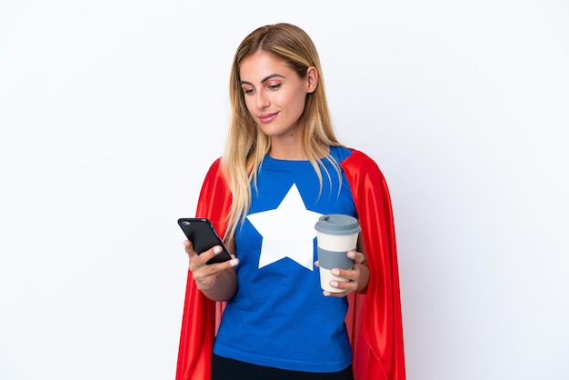 Super hero caucasian woman isolated background holding coffee\
to take away and a mobile