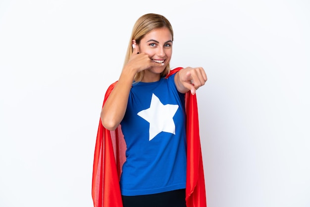 Super Hero caucasian woman isolated background making phone gesture and pointing front