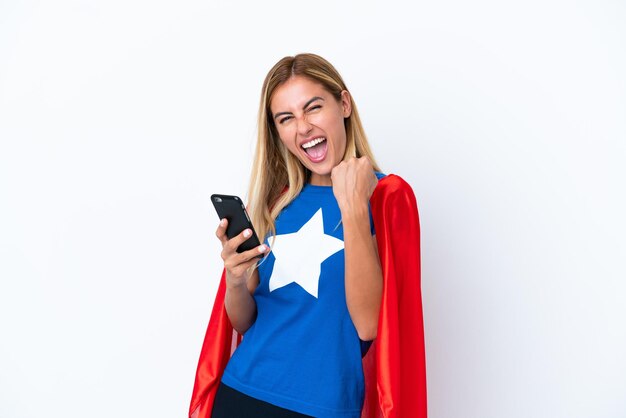 Super Hero caucasian woman isolated background with phone in victory position