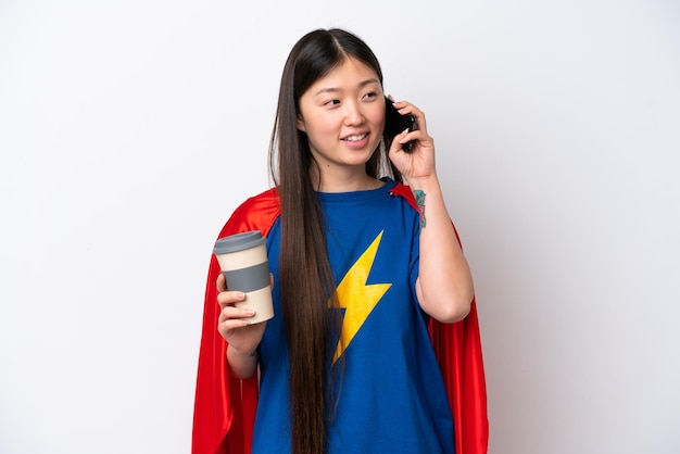 Super Hero Chinese woman isolated on white background holding coffee to take away and a mobile