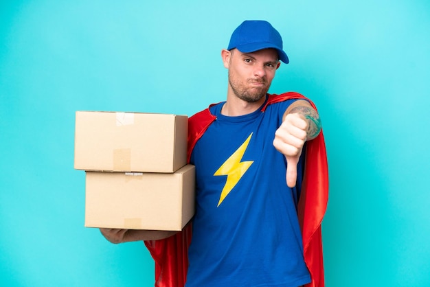 Super Hero delivery man over isolated background showing thumb down with negative expression