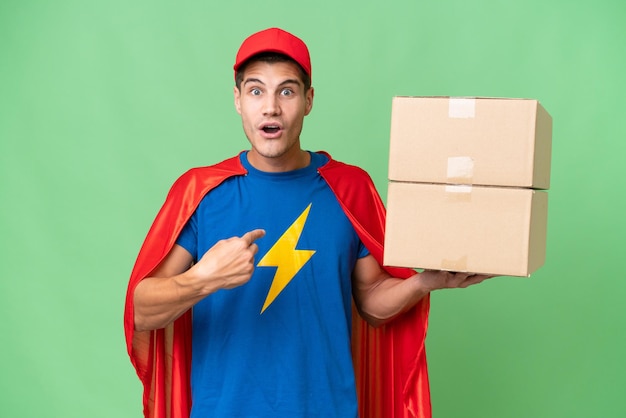 Super Hero delivery man over isolated background with surprise facial expression