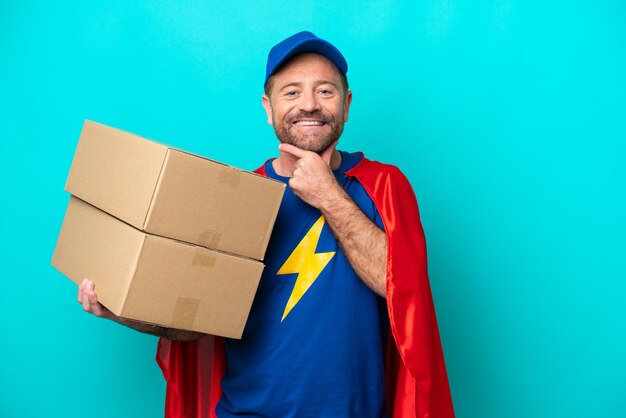 Photo super hero delivery man isolated on blue background happy and smiling