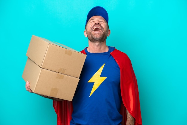 Super Hero delivery man isolated on blue background laughing