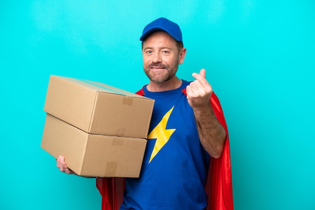 Super Hero delivery man isolated on blue background making money gesture