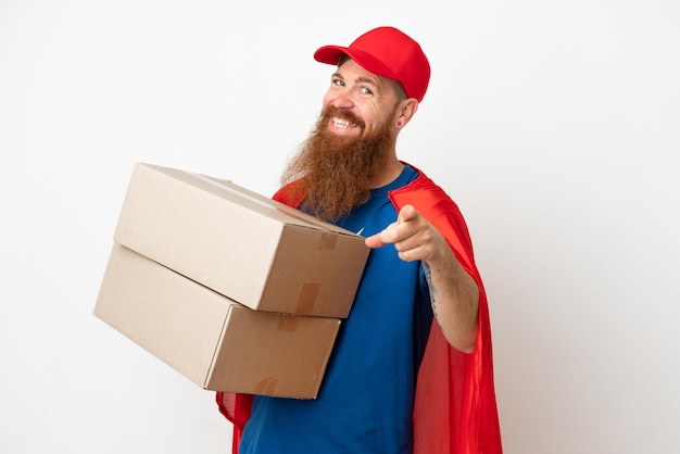 Super Hero delivery reddish man isolated on white background pointing front with happy expression