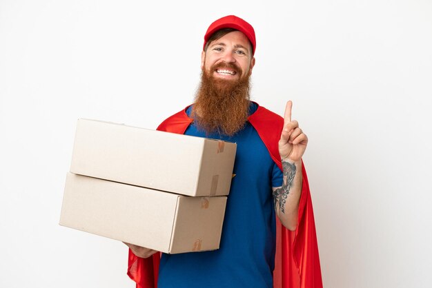 Super Hero delivery reddish man isolated on white background showing and lifting a finger in sign of the best