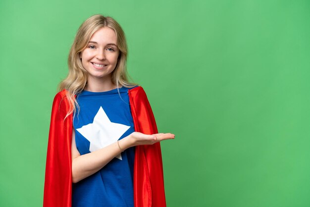 Super Hero English woman over isolated background presenting an idea while looking smiling towards