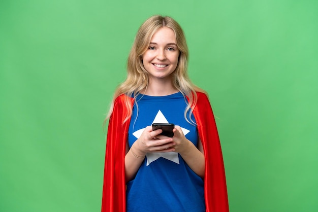 Super Hero English woman over isolated background sending a message with the mobile