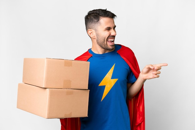 Super Hero levering blanke man over geïsoleerde witte achtergrond wijzende vinger naar de zijkant en een product presenteren