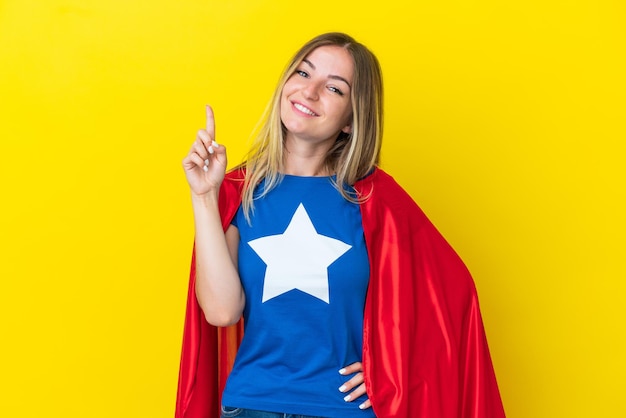 Super Hero Roemeense vrouw geïsoleerd op een gele achtergrond die een vinger toont en opheft in teken van de beste