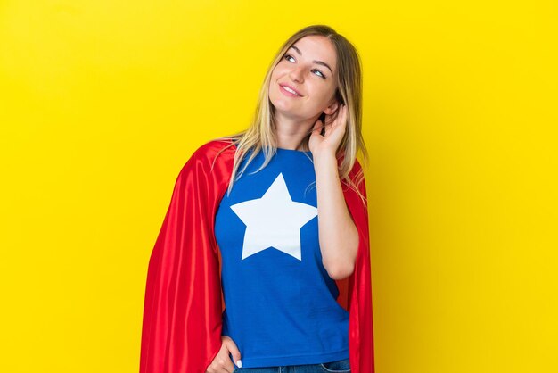 Super Hero Romanian woman isolated on yellow background thinking an idea