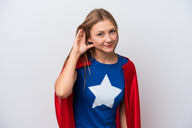 Super Hero Russian woman isolated on white background listening to something by putting hand on the ear