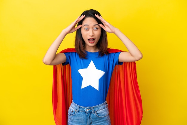 Super hero vietnamese woman isolated on yellow background with surprise expression