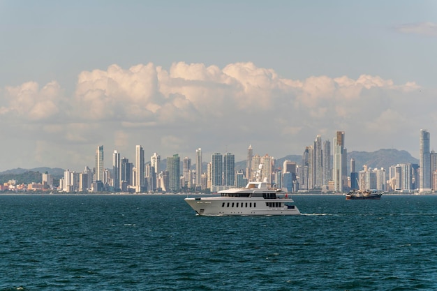 Super luxe jacht met witte romp met Panama-stad op achtergrond