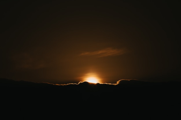 Super sunset over the black clouds wallpaper on moody tones and orange tones