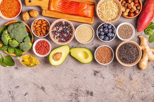 Superfoods on gray concrete background. Healthy food clean eating concept. Top view.