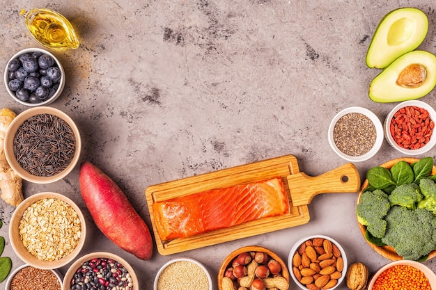 Superfoods on gray concrete background. Healthy food clean eating concept. Top view.