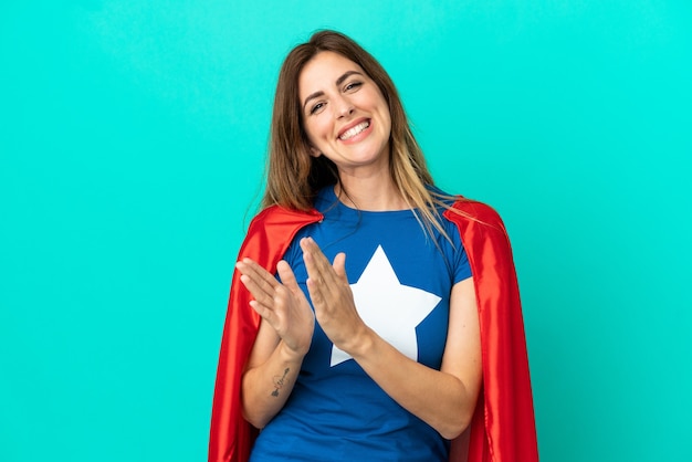 Superheld blanke vrouw geïsoleerd op blauwe achtergrond applaudisseren na presentatie in een conferentie