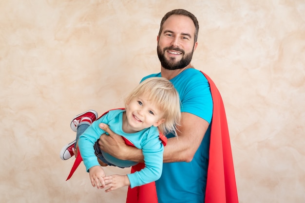 Superheld van man en kind thuis. Superheld vader en zoon samen plezier.