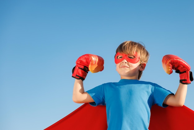 Photo superhero child against summer blue sky