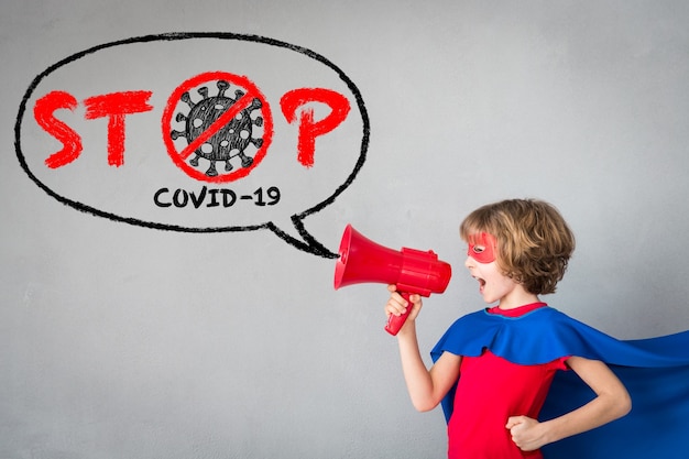 Superhero child speaking by loudspeaker about COVID-19.