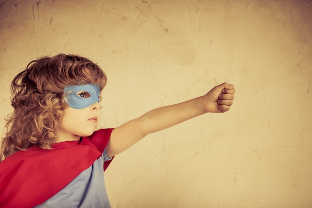 Superhero kid against grunge concrete background