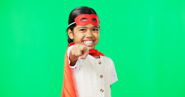 Superhero point and face of child on green screen for fantasy cosplay costume and comic character choose gesture hero mockup and portrait of girl in studio for freedom fight crime and games