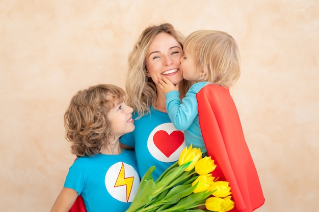 Superhero woman and children at home