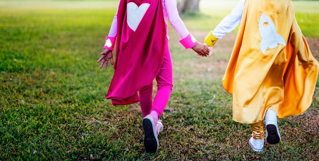 Amici dei bambini dei supereroi che giocano concetto di divertimento di unità