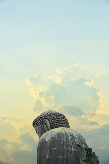 Foto sovrapposto al grande buddha della città di kamakura in giappone con nubi drammatiche e pacifiche