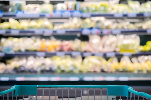 Supermarket aisle with empty red shopping cart