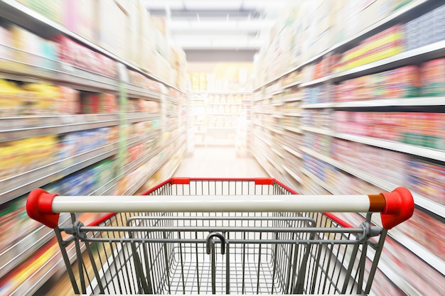 Supermarket aisle with empty red shopping cart