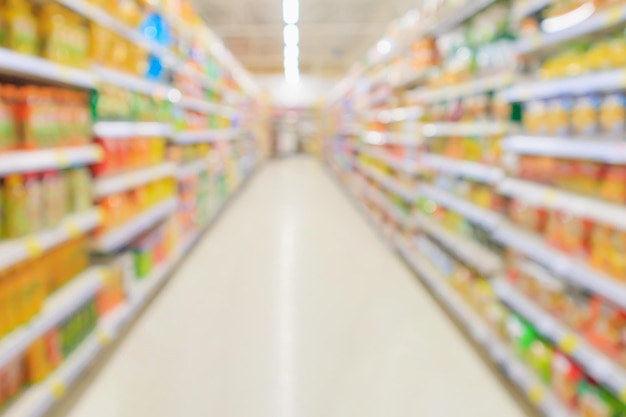 Supermarket aisle with product shelves interior defocused blur background