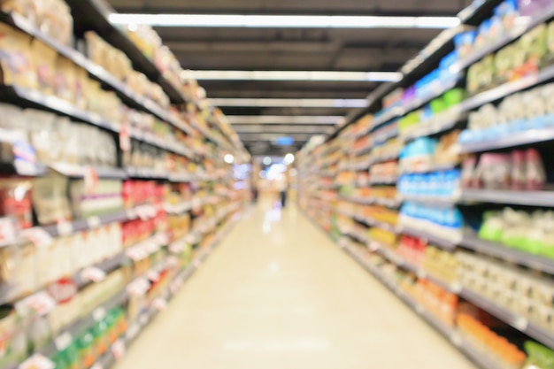 Photo supermarket aisle with product shelves interior defocused blur